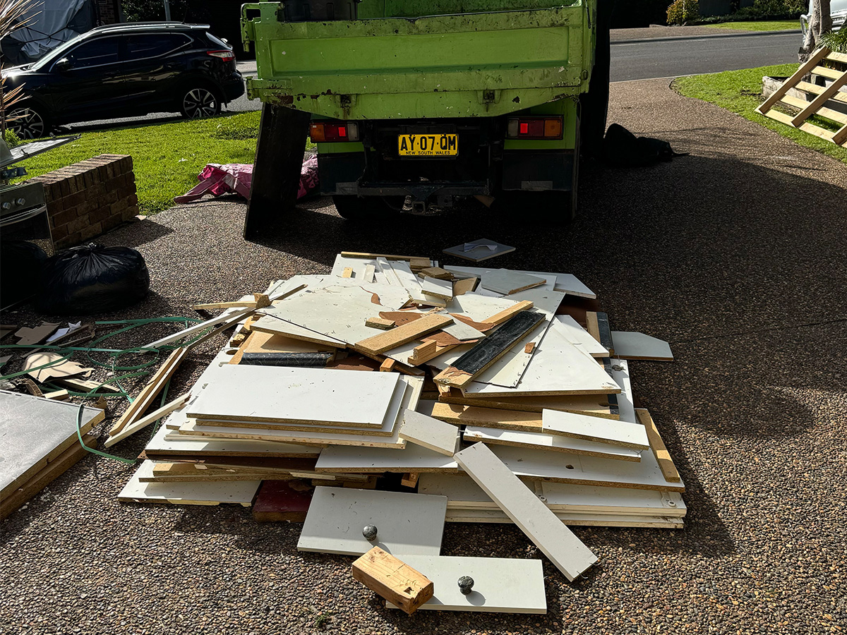 Waste truck in Albion Park parked in front of kitchen cabinet waste, ready for removal of the rubbish.